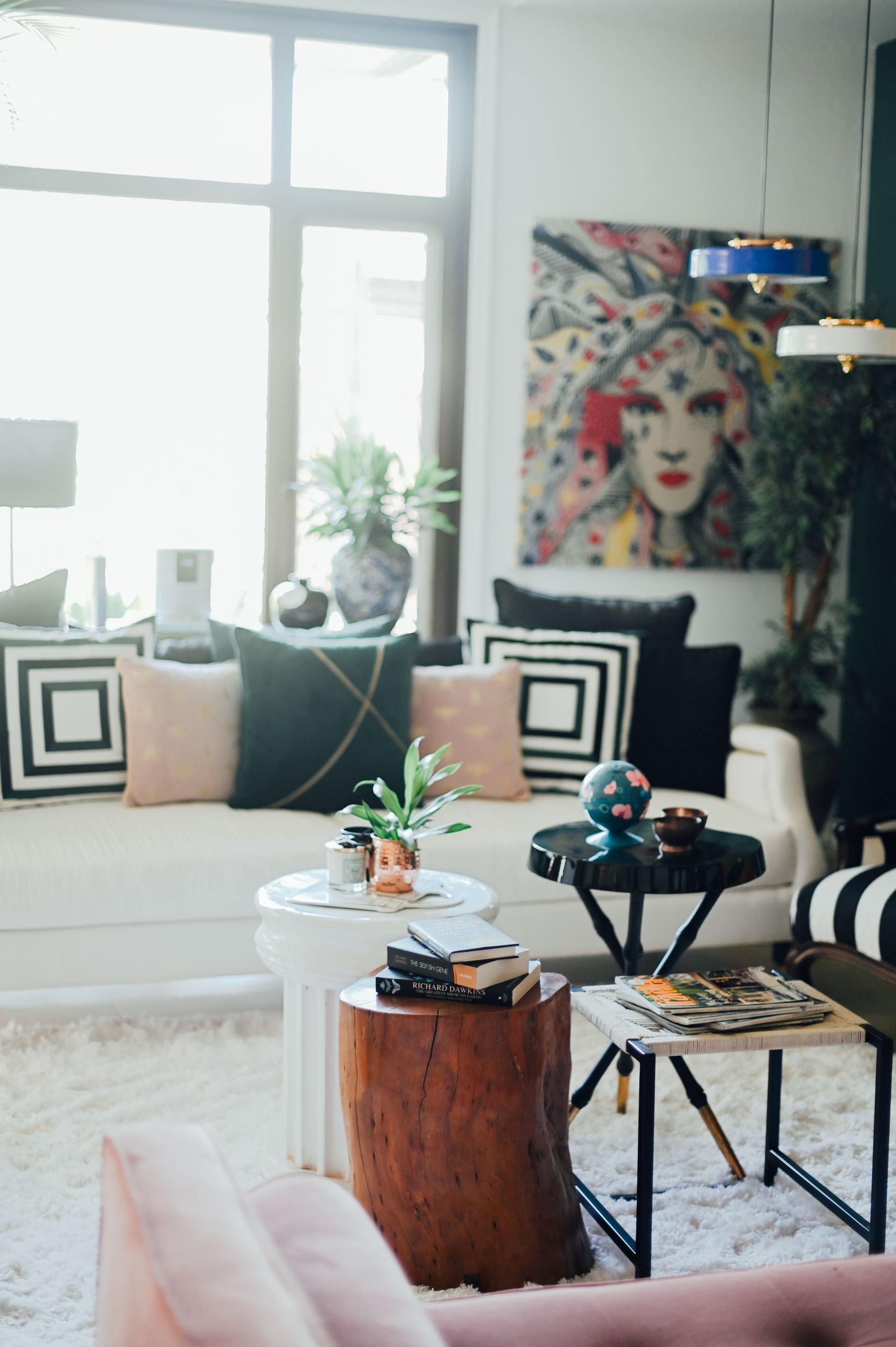 Living room corner with a graphic portrait artwork and a tree-stump side table