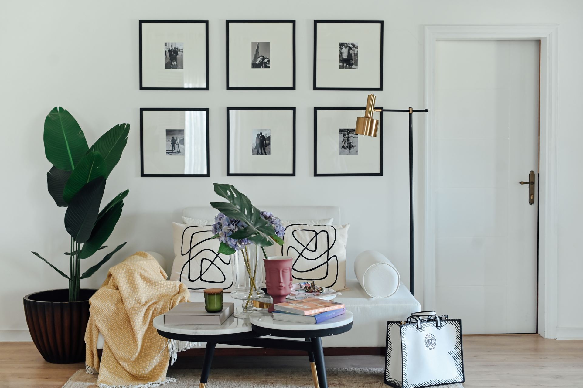 Gallery wall of black-and-white photographs above a cream sofa