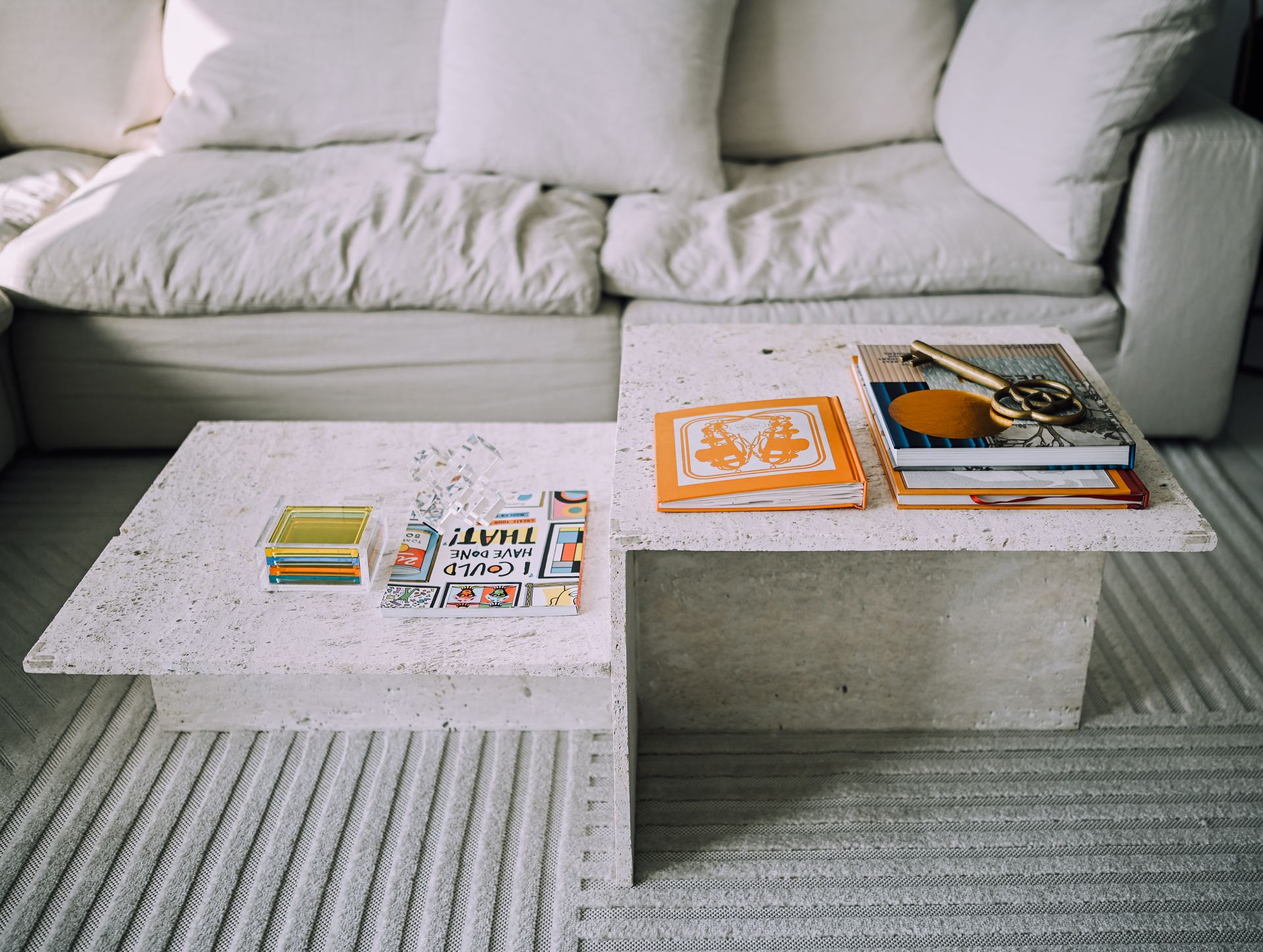 Split-level concrete coffee table with magazines in front of a linen sofa