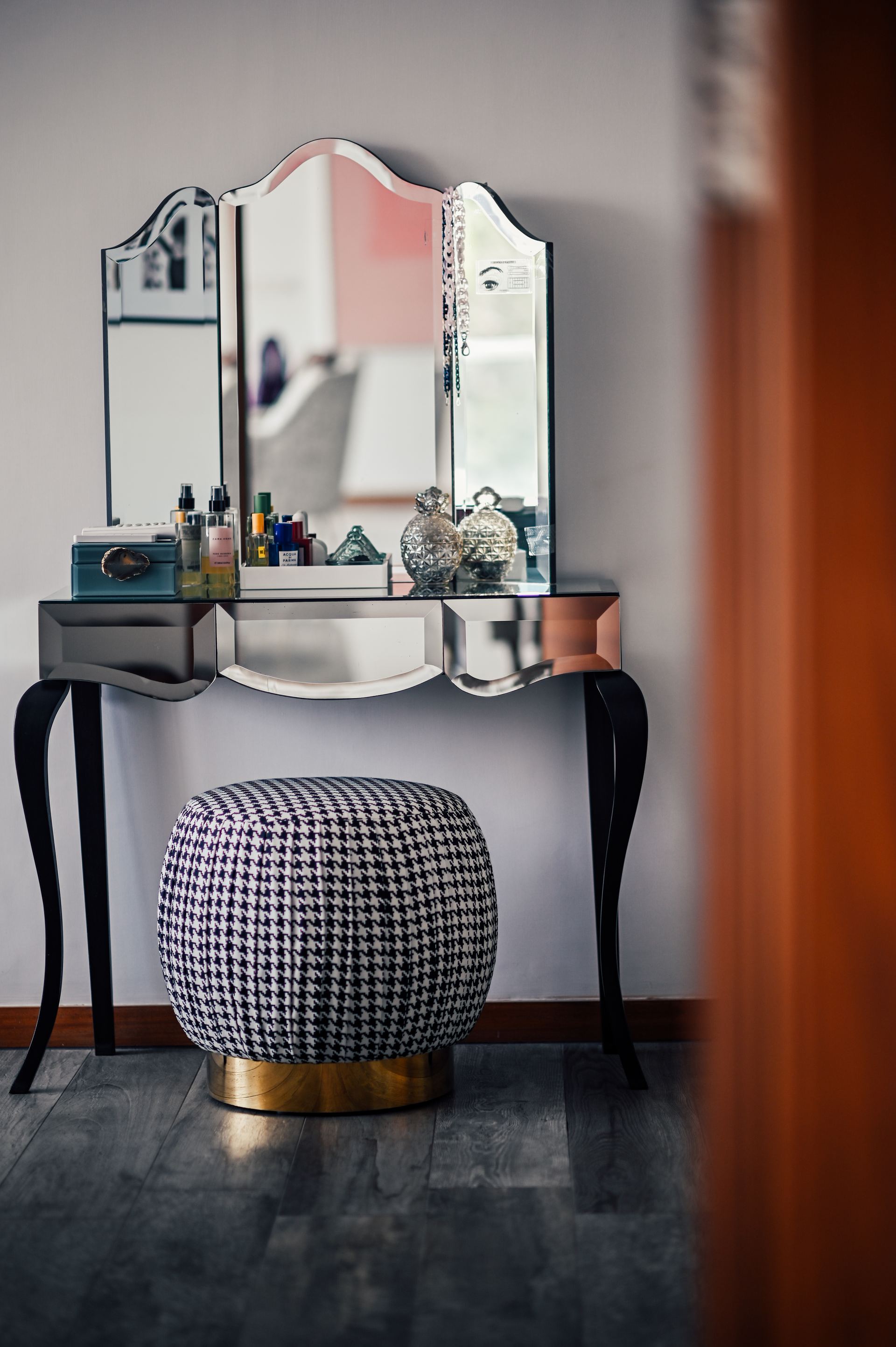 Mirrored vanity table with a scalloped tri-fold mirror and houndstooth stool