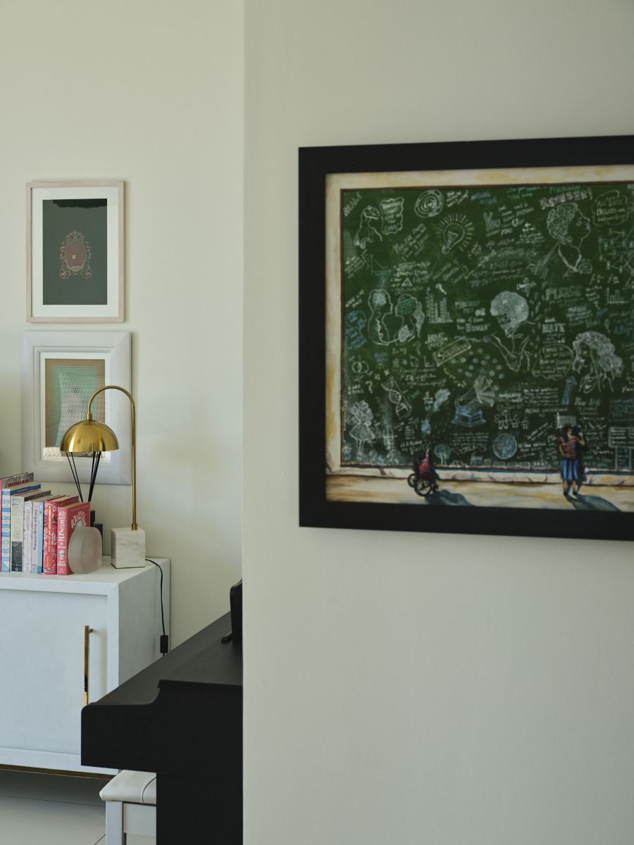 Framed chalkboard-style artwork beside a white cabinet stacked with books