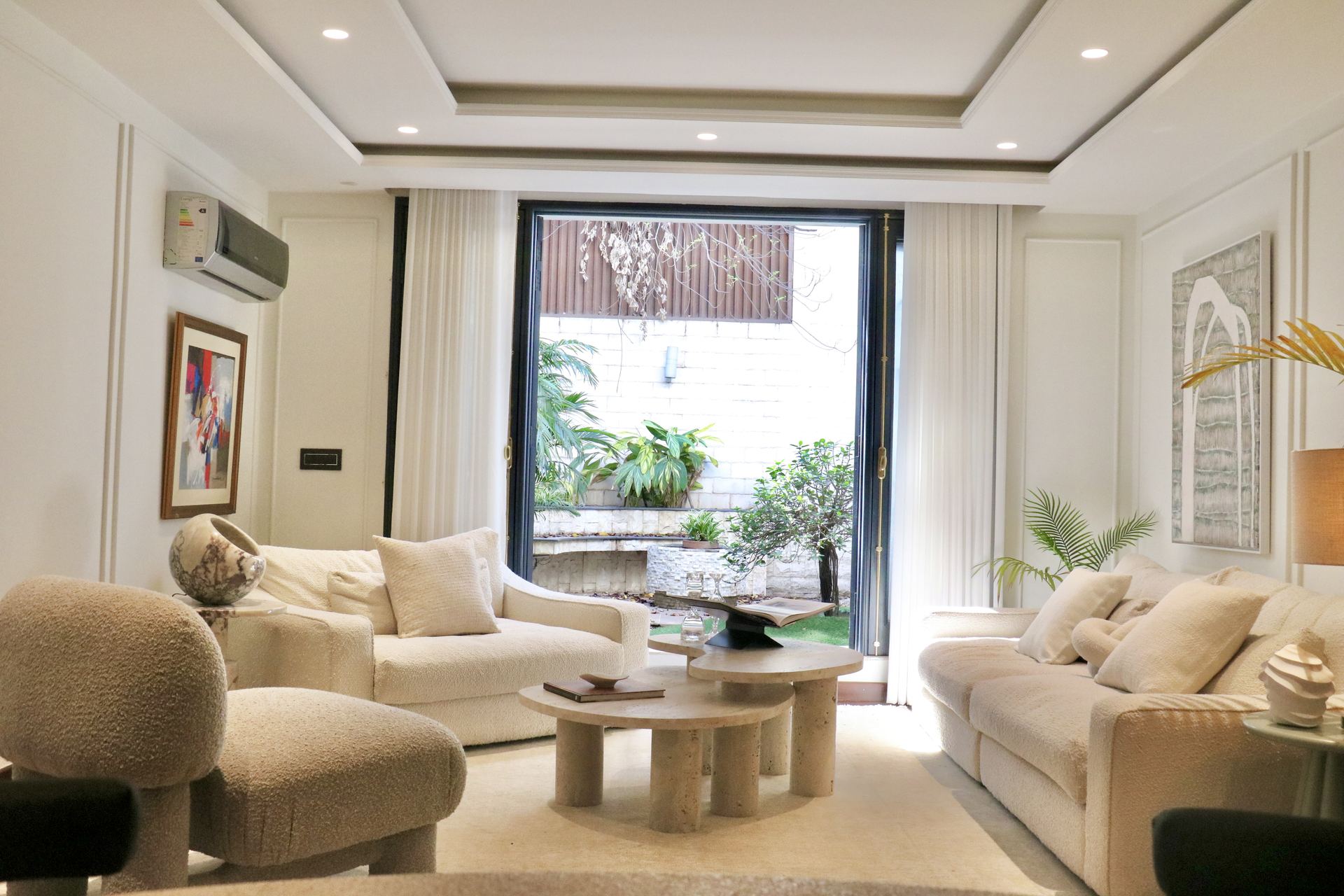 Cream living room with travertine coffee tables opening onto a courtyard