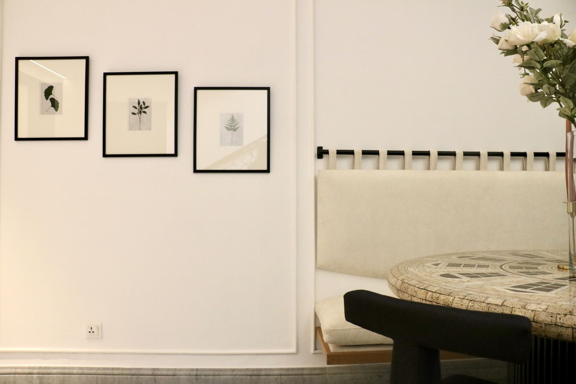 Framed botanical prints beside a built-in banquette