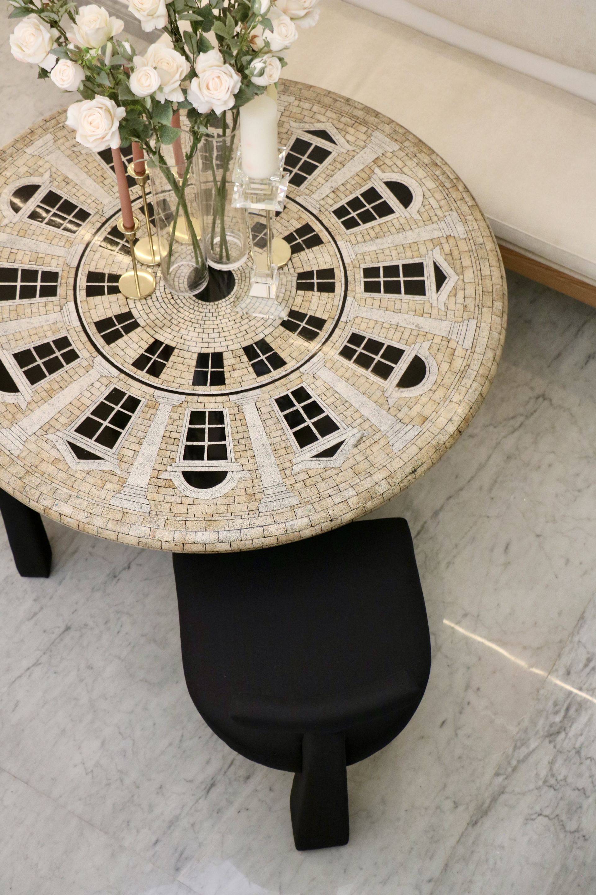 Overhead view of a mosaic dining table set with roses and a candle