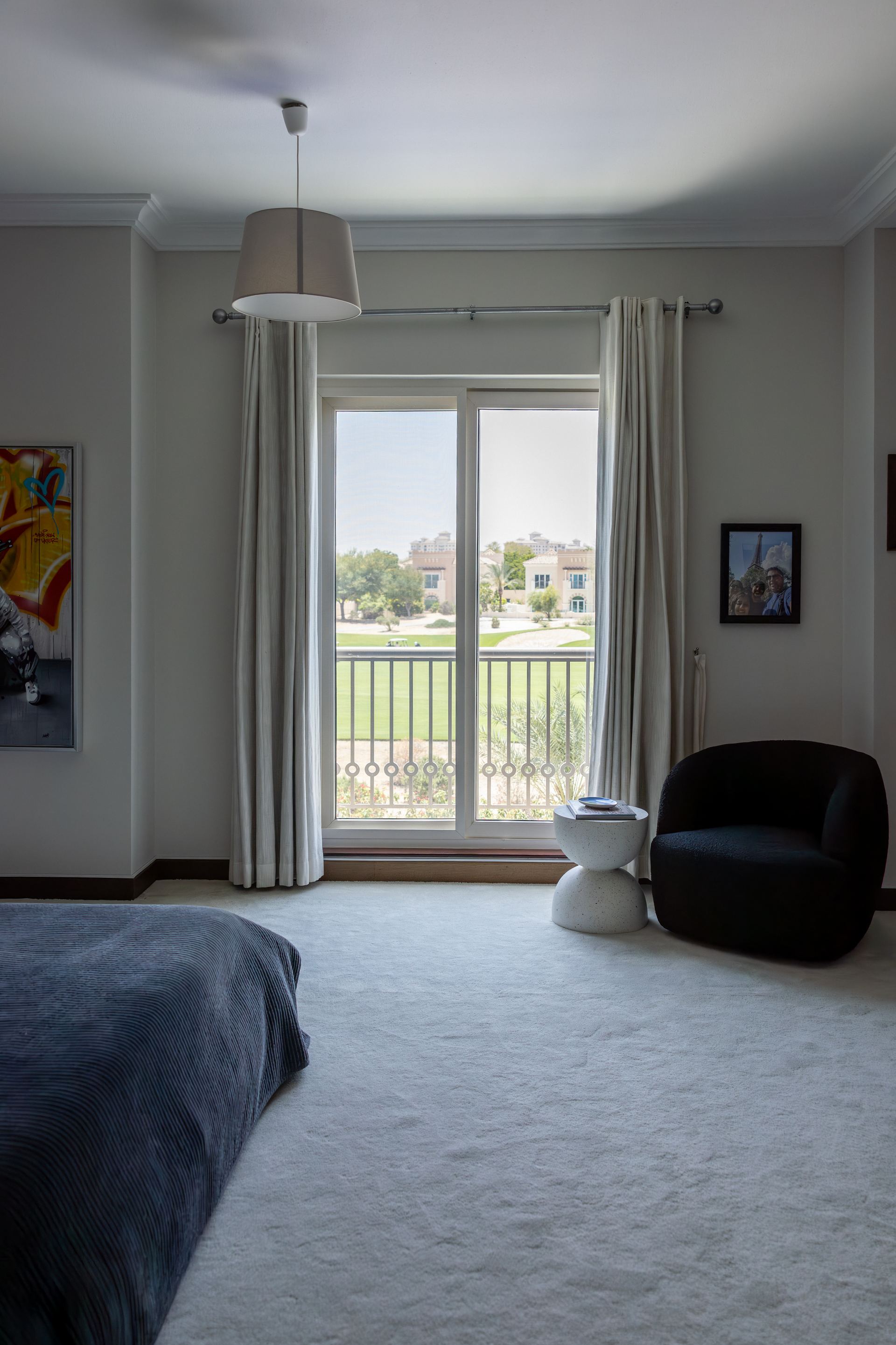 Navy velvet bedspread with a graffiti-style portrait painting and a golf-course view