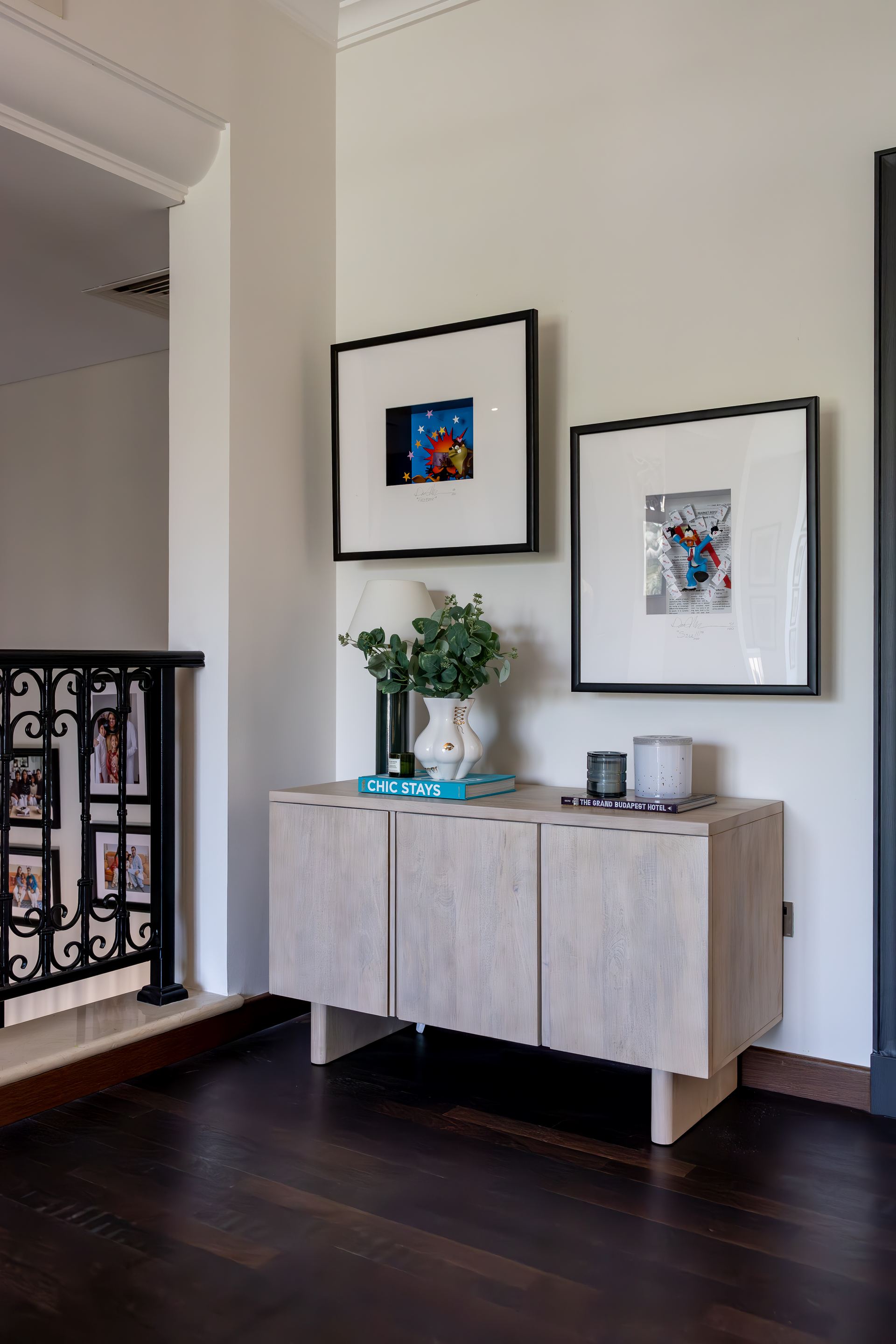 Whitewashed sideboard styled with framed illustrations and a ceramic rabbit vase