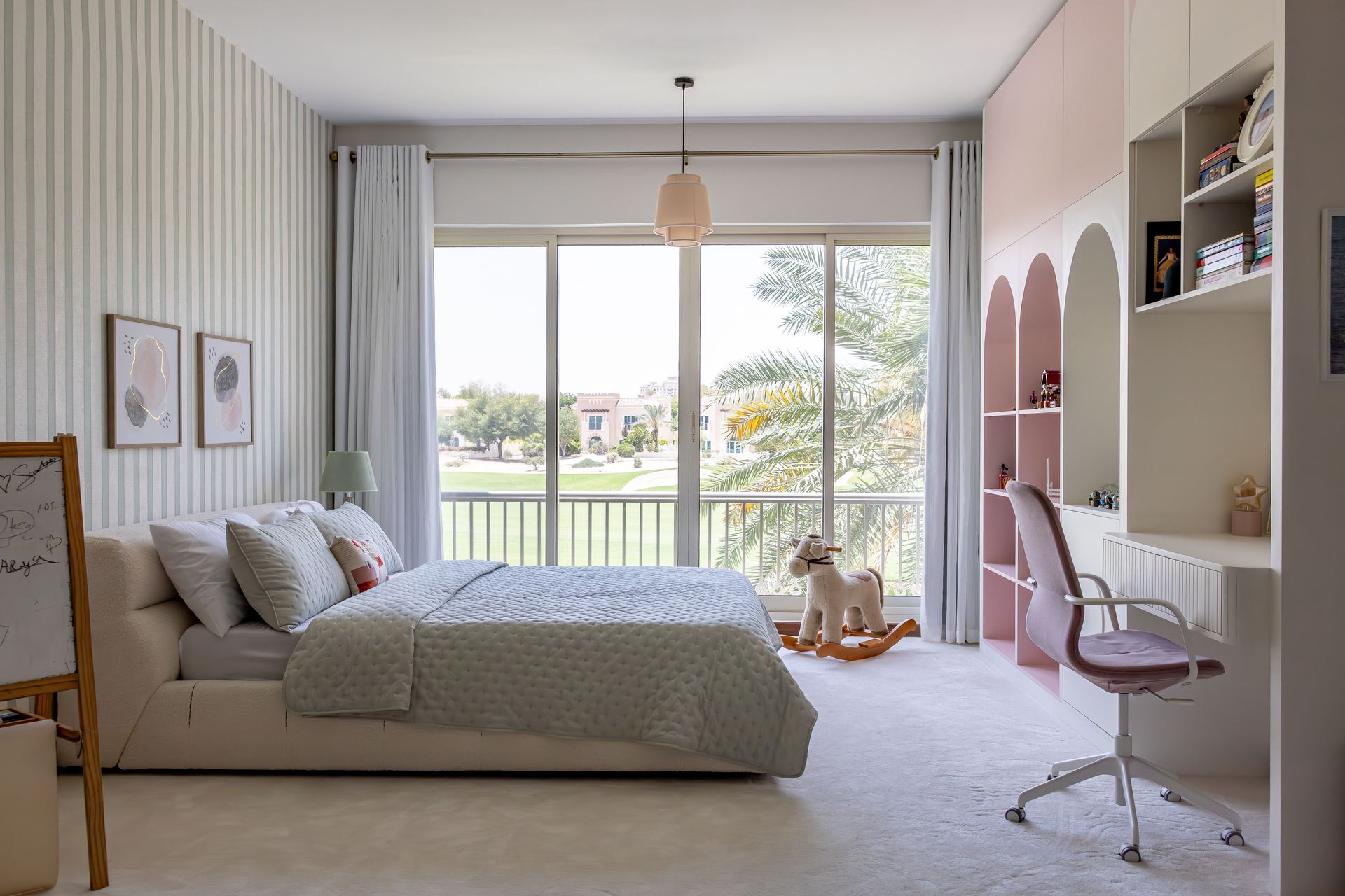 Striped-wallpaper bedroom with a pastel pendant light and garden view