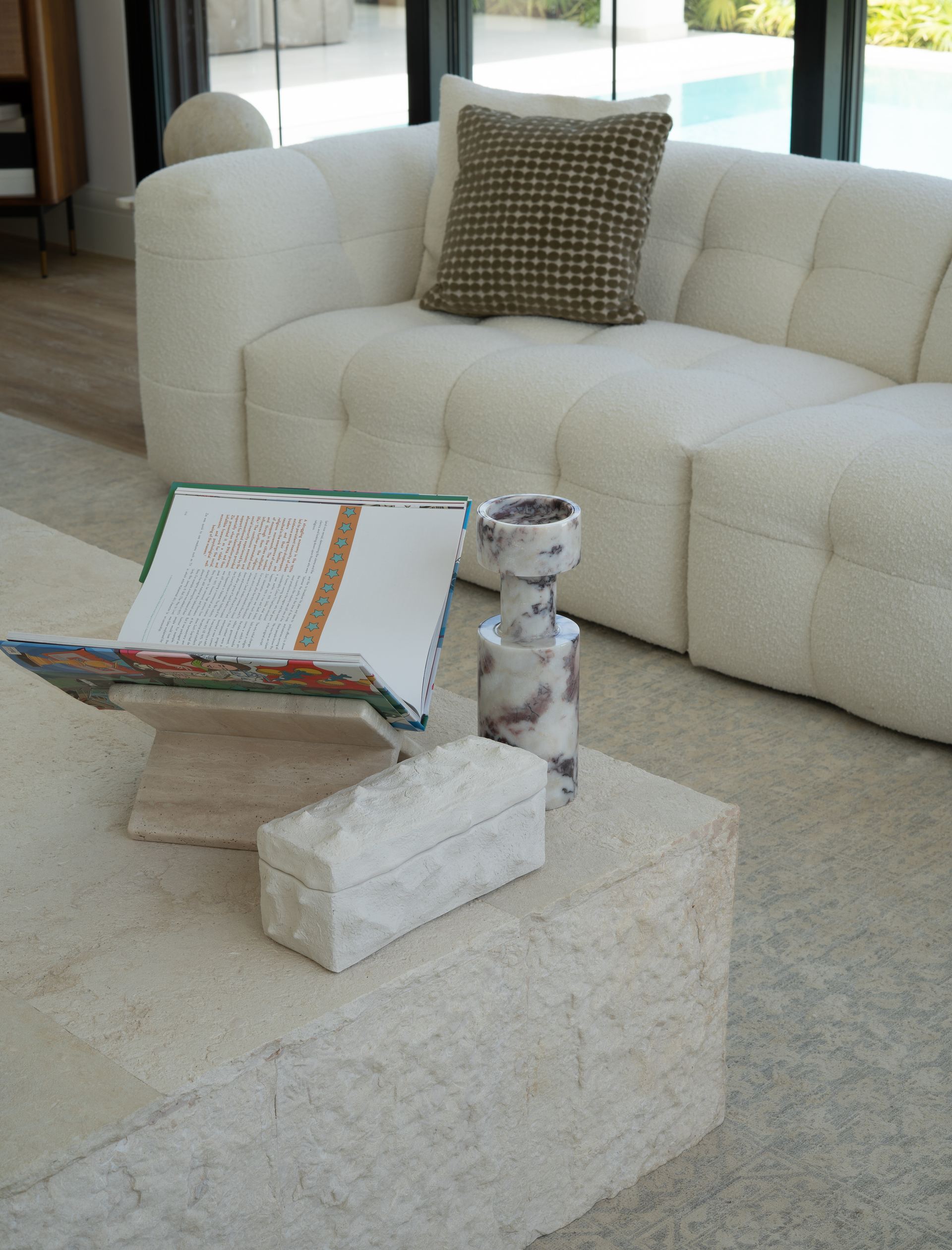 Marble candle holders and a stone box styled on a travertine coffee table
