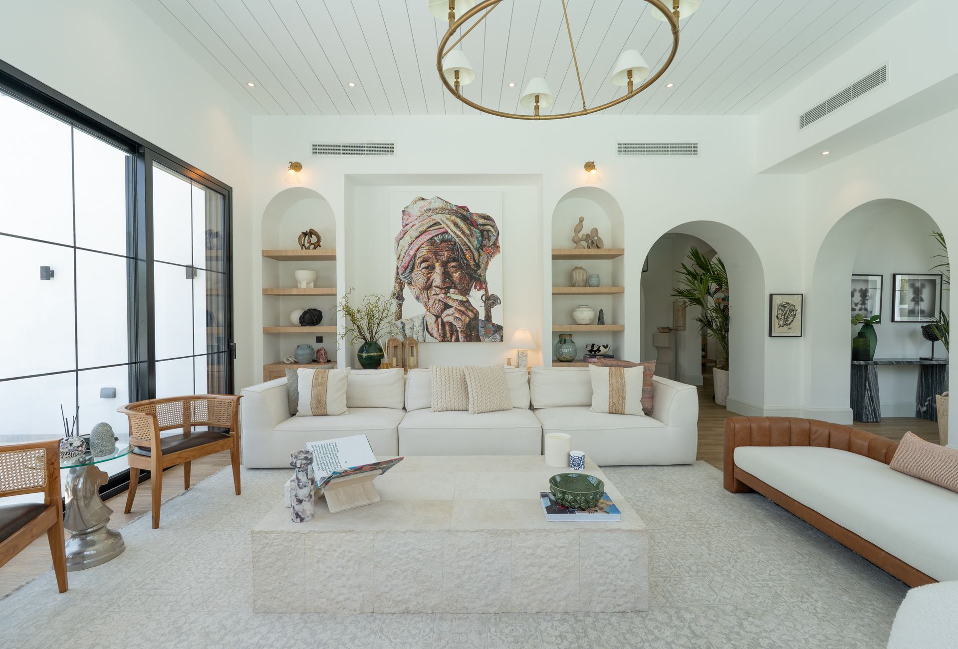 Arched living room alcove with a portrait painting flanked by curved display shelves