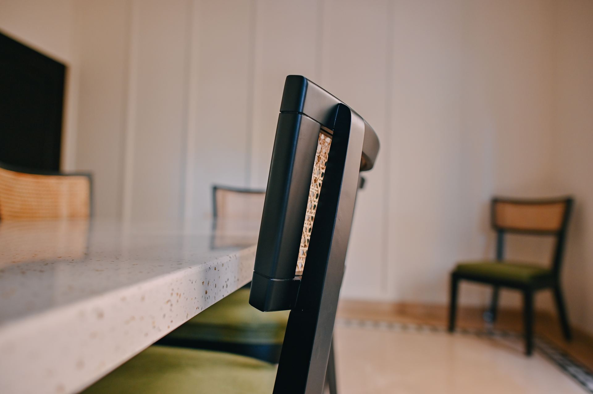 Black-and-white detail of a leather dining chair beside a marble table