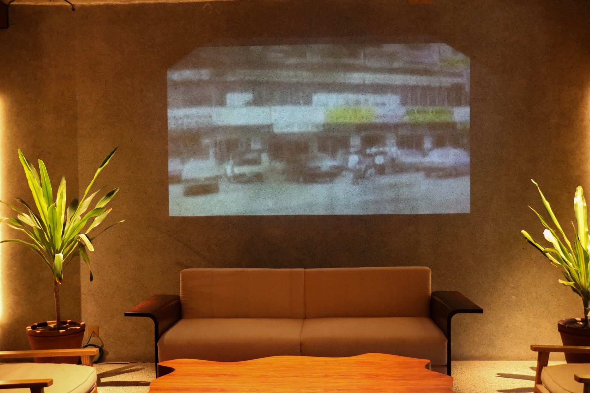 Vintage archival photograph projected above a lounge sofa and walnut coffee table