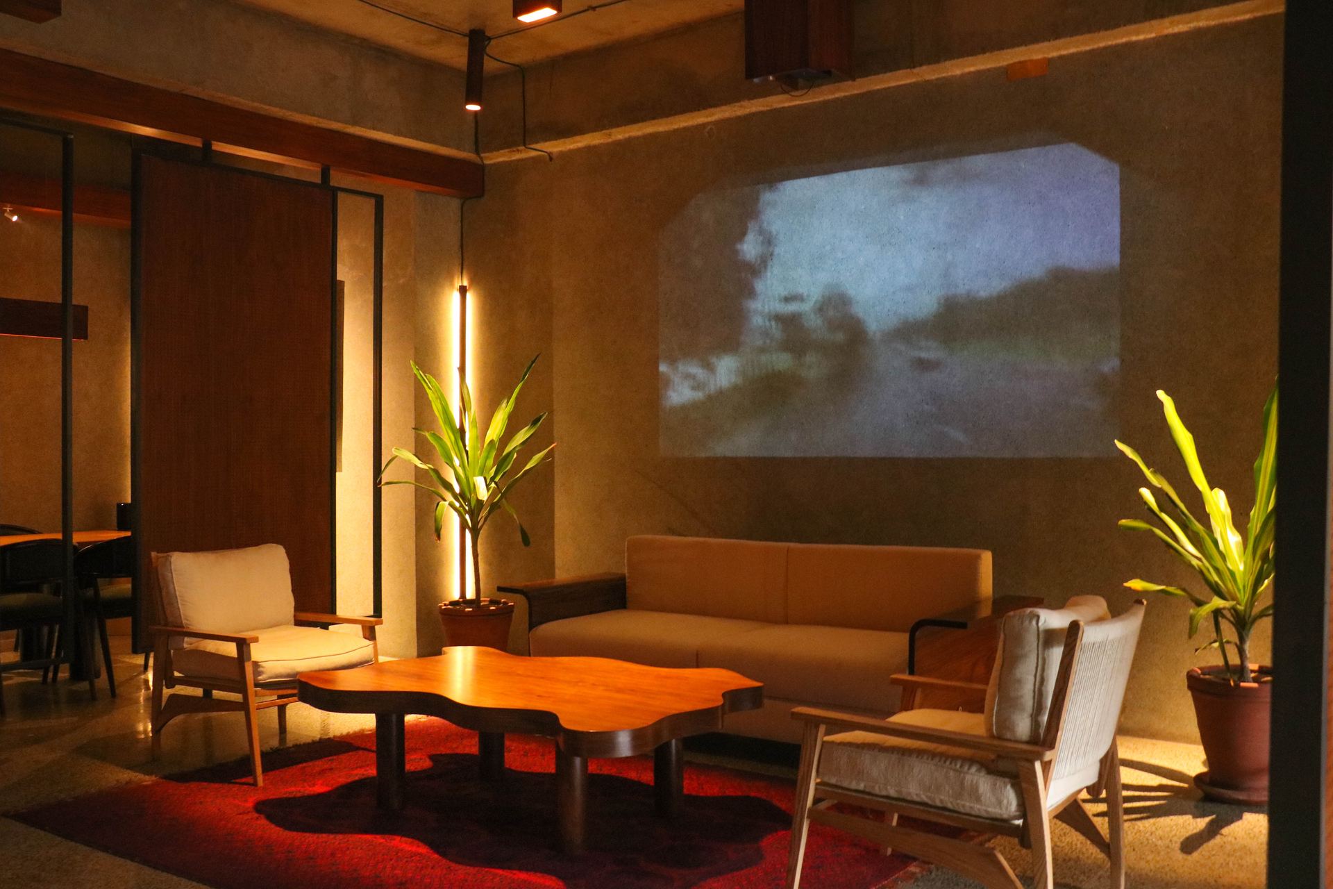 Lounge seating and a live-edge coffee table beneath a projected vintage film